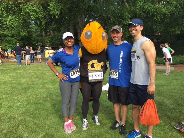 Slide Show Image #4: Four CareerBuilder employees after a marathon, wearing their race numbers and standing next to the Georgia Tech mascot